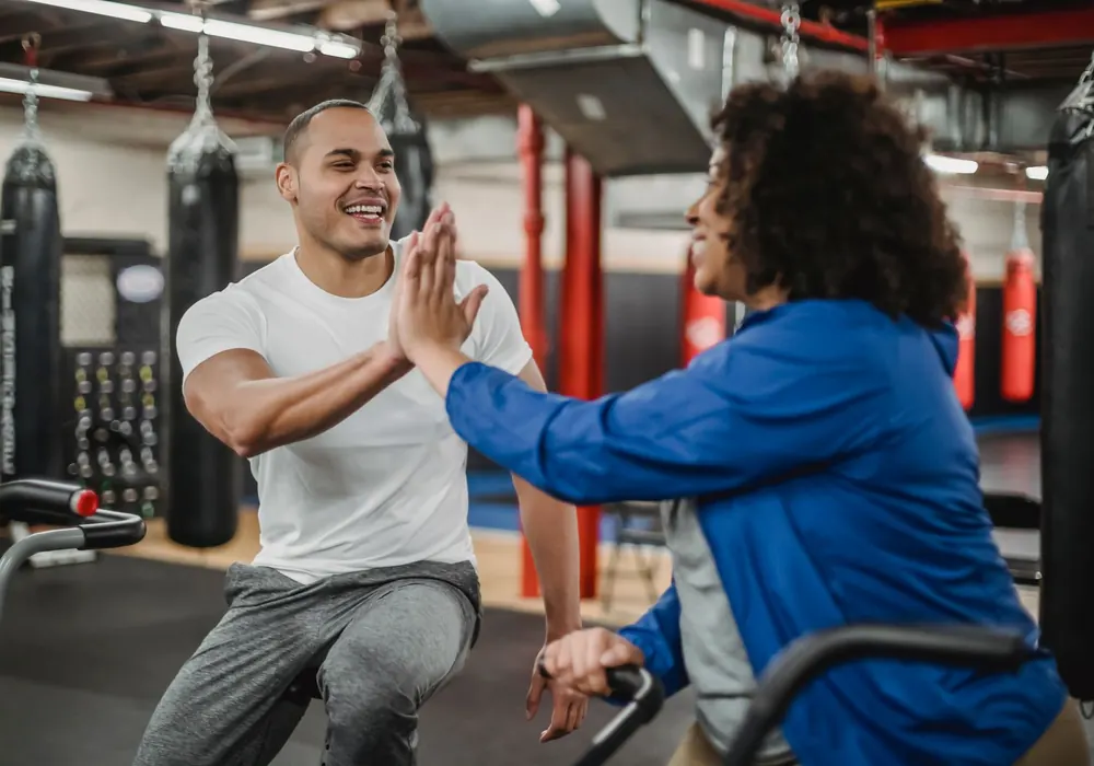 Personal trainer comemorando com aluna durante o treino